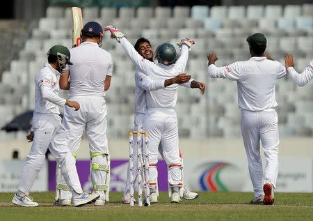 Cricket - Bangladesh v England - Second Test cricket match - Sher-e-Bangla Stadium, Dhaka, Bangladesh - 29/10/16. Bangladesh's Mehedi Hasan Miraz (C) celebrates with his captain Mushfiqur Rahim after taking the wicket of England's Jonny Bairstow. REUTERS/Mohammad Ponir Hossain