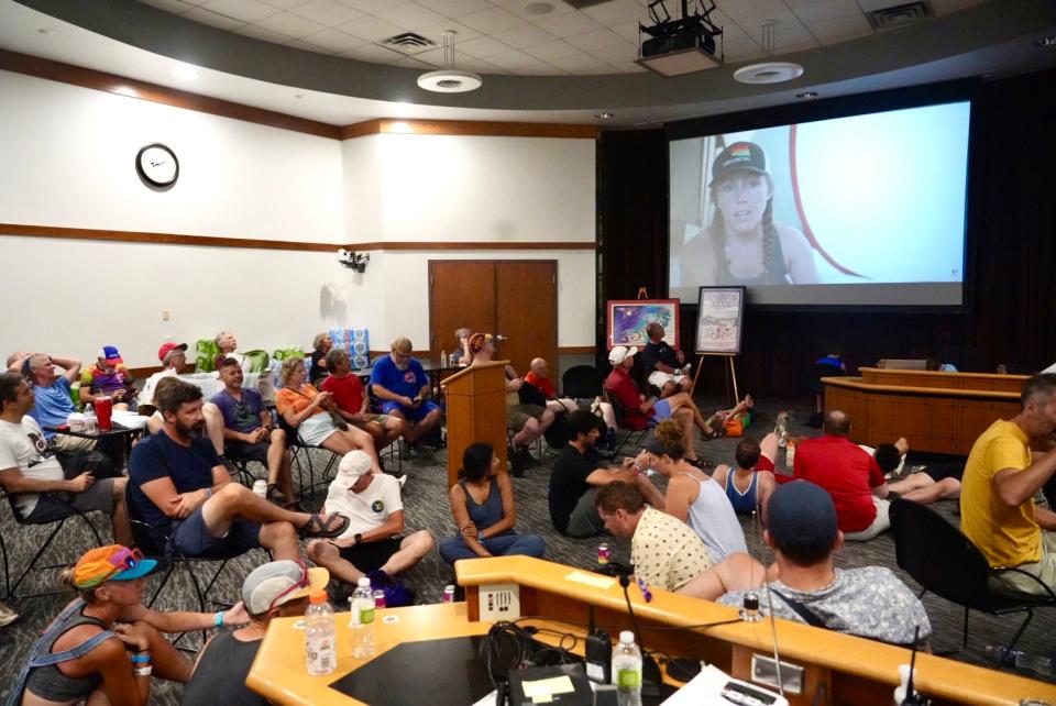 People sheltering from a storm watch a video in the Coralville City Council chambers adjacent to the RAGBRAI campground in S.T. Morrison Park.