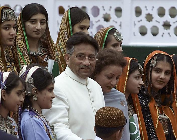FILE - Pakistani President Gen. Pervez Musharraf, center, and his wife Sehba Musharraf, 3rd right, pose with Pakistani children clad in traditional dresses during the 54th anniversary celebration of Pakistan's Independence Day at Presidential palace in Islamabad, Pakistan on Aug 14, 2001. Gen. Pervez Musharraf, who seized power in a bloodless coup and later led a reluctant Pakistan into aiding the U.S. war in Afghanistan against the Taliban, has died, an official said Sunday, Feb. 5, 2023. He was 79. (AP Photo/B.K.Bangash, File)