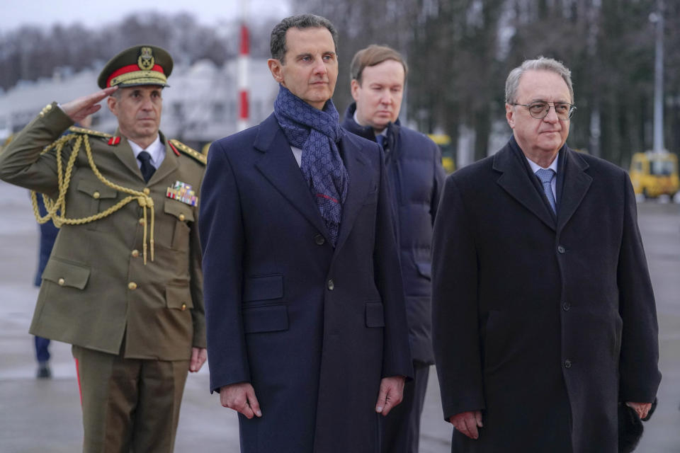 In this photo released by the Syrian official news agency SANA, visiting Syrian President Bashar Assad, left, and Mikhail Bogdanov, right, Deputy Minister of Foreign Affairs of Russia and Special Representative of the President of Russia for the Middle East, review an honor guard during a welcome ceremony upon Assad's arrival at Vnukovo airport in Moscow, Russia, Tuesday, March 14, 2023. Assad landed in Russia Tuesday where he is scheduled to meet top ally President Vladimir Putin. (SANA via AP)