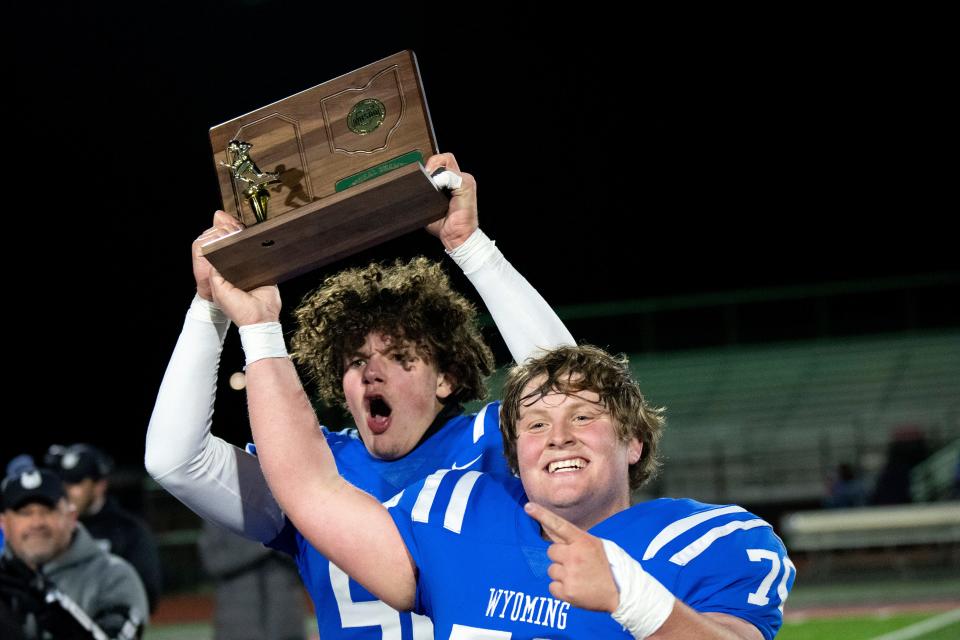 Wyoming offensive linemen Wyatt Metz (70) and Theo Davis (50) hold up the regional trophy after winning the OHSAA DIV regional final football game over Taft High School Saturday.