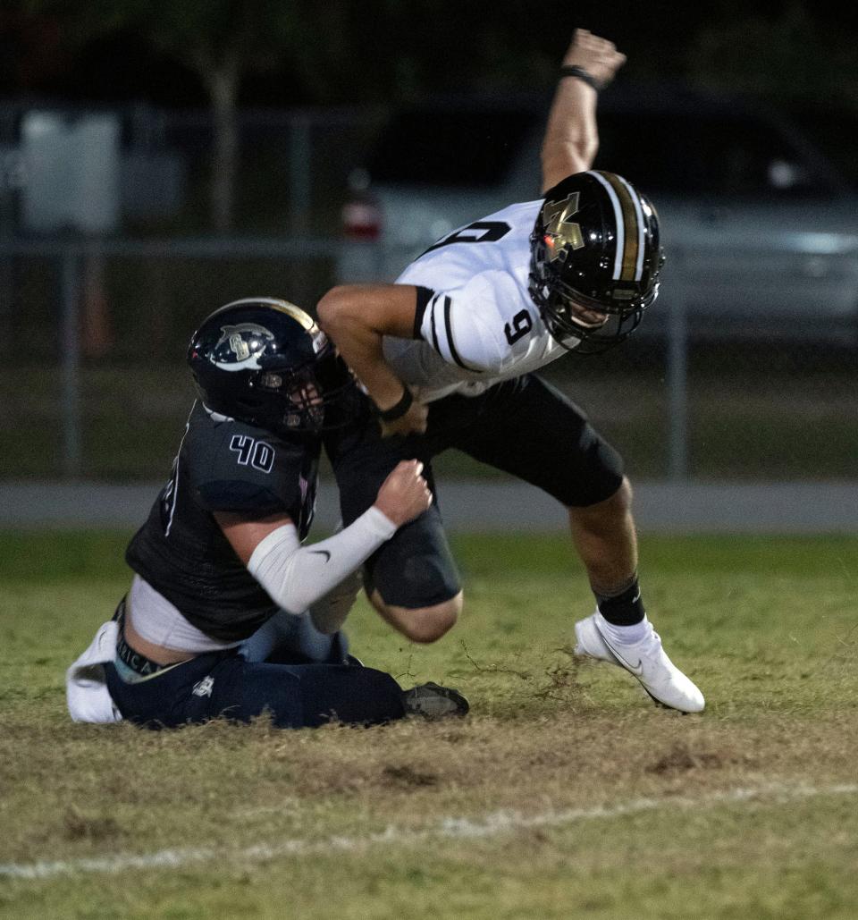 Milton quarterback Emory Williams (No. 9) gets tackled for a loss and a fumble by Gulf Breeze's Turner McLaughlin (No. 40) during Friday night's football game against the Panthers.