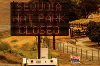 A sign announces the closure of Sequoia National Park, where the KNP Complex Fires are burning, Tuesday, Sept. 14, 2021, in Tulare County, Calif. Individually named the Colony and Paradise Fires, the blazes are burning near the Giant Forest, home to more than 2,000 giant sequoias. (AP Photo/Noah Berger)