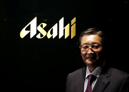 Asahi Group Holdings President and COO Akiyoshi Koji poses for a photo with the company's logo at its headquarters in Tokyo, Japan, May 17, 2016. REUTERS/Toru Hanai