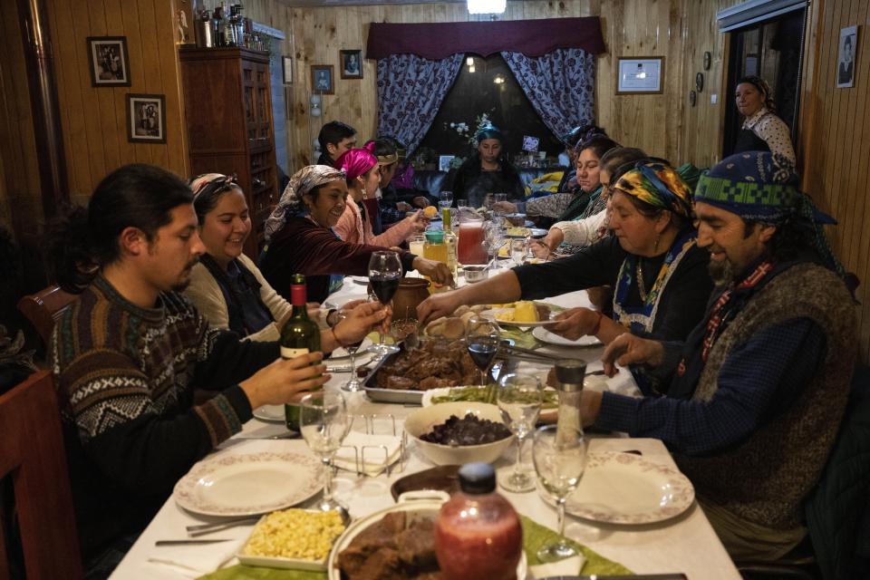 The Huenchupan family eats dinner during multiday celebrations of We Tripantu, the Mapuche new year, in Lof Soyinka, Los Rios, southern Chile, on Wednesday, June 22, 2022. (AP Photo/Rodrigo Abd)