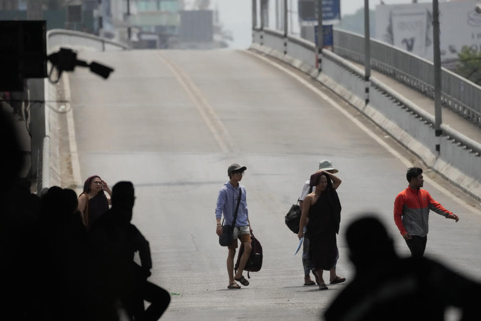 Myanmar buddhist monks and tourists cross the 1st Thai-Myanmar Friendship Bridge in Mae Sot in Thailand's Tak province on Friday, April 12, 2024. Thailand’s foreign minister says he has urged Myanmar’s military authorities not to violently respond to its army’s loss of an important border trading town to its opponents, and that so far it seemed to be exercising restraint. (AP Photo/Sakchai Lalit)