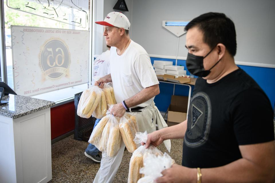 Nick Poulos helps a customer take his order out to his car at Superior Bakery on Wednesday, April 19, 2023.