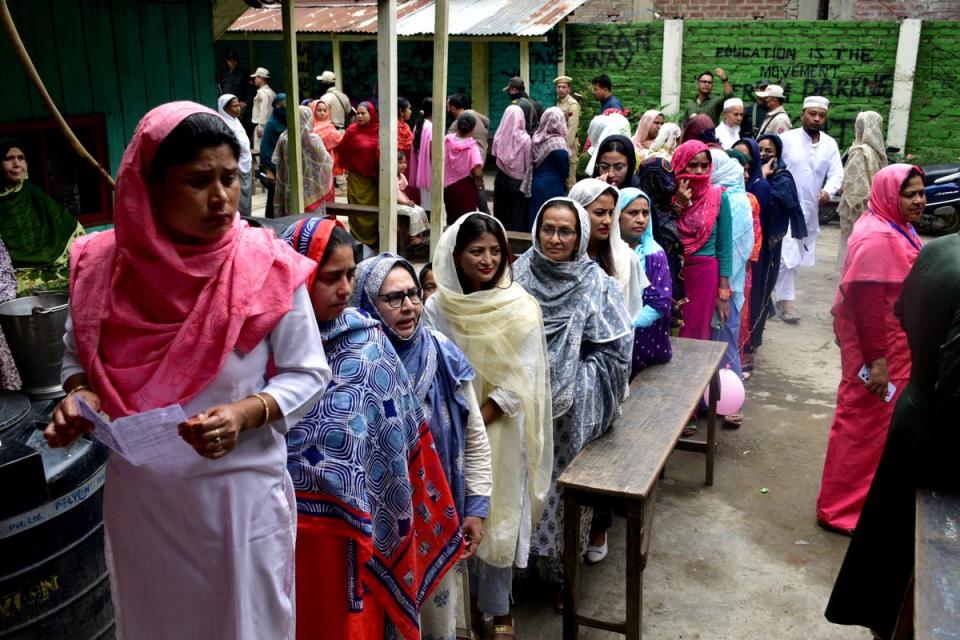 Women wait to cast their votes at a polling station during the first phase of the general election, in Imphal, Manipur (Reuters)