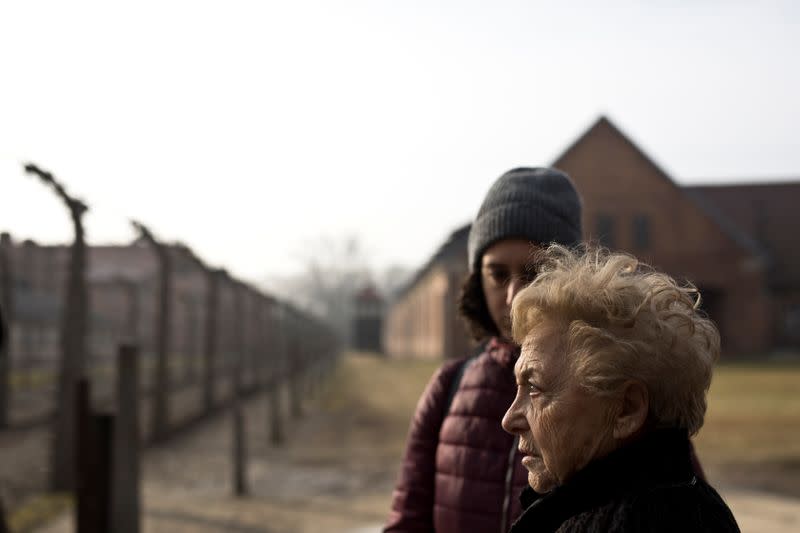 Jona Laks, survivor of Dr. Josef Mengele's twins experiments, and her granddaughter, Lee Aldar stand next to the gate as they as they enter to visit Auschwitz death camp in Oswiecim