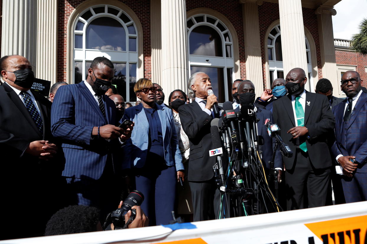 The Reverend Al Sharpton, holding a microphone, and other Black pastors stand outside the Glynn County courthouse in Brunswick, Georgia.