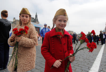 Girls hold flowers after the Victory Day parade, which marks the anniversary of the victory over Nazi Germany in World War Two, in Red Square in central Moscow, Russia May 9, 2019. REUTERS/Maxim Shemetov