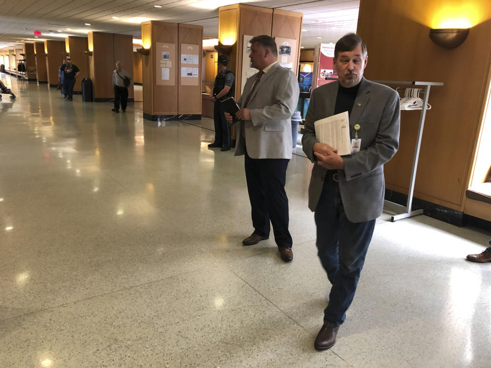 Sen. Brian Boquist, right, enters a hearing room at the state capital in Salem, Ore. on Monday, July 8, 2019. A special committee of the Oregon state Senate is holding a hearing over the lawmaker's comments he made during a Republican revolt over climate legislation.(AP Photo/Andrew Selsky)