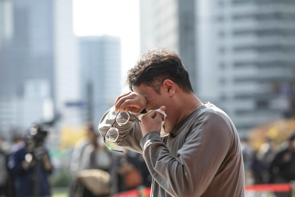 SEOUL, SOUTH KOREA - OCTOBER 31: A visitor mourns after he paid tribute at the alter set up at Seoul City Hall Plaza in Seoul, South Korea on October 31, 2022. (Photo by Jean Chung for The Washington Post via Getty Images)