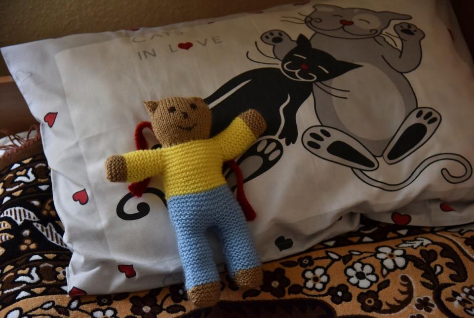 A soft toy wearing the Ukrainian flag colours is placed on a bed at Lelechenya (Little Stork) rehabilitation centre in Dzhuriv (Reuters)