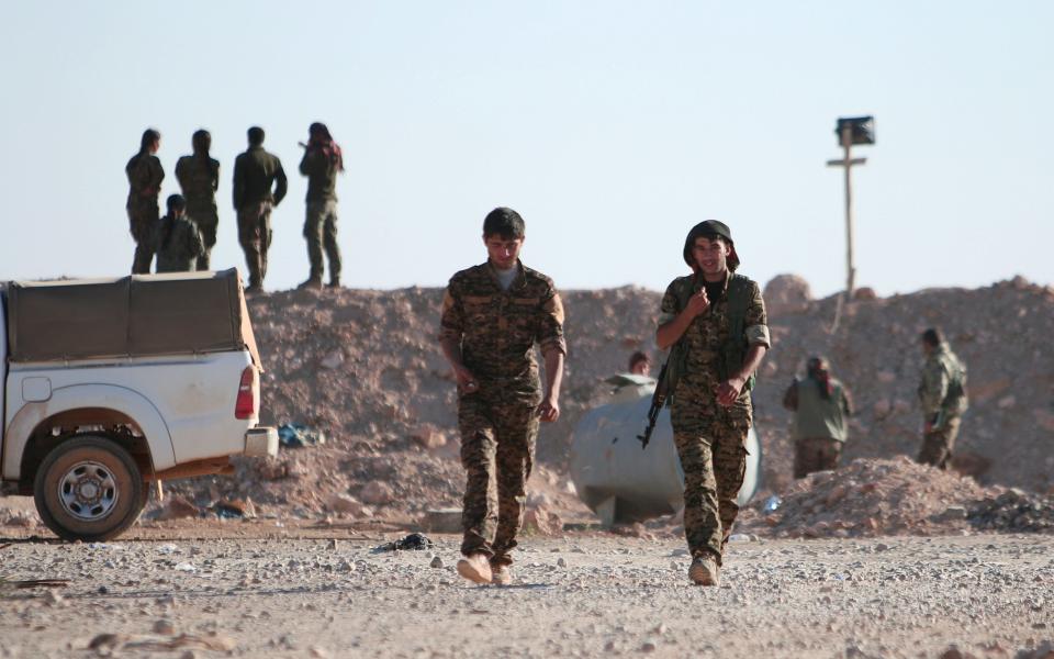 Syrian Democratic Forces (SDF) fighters walk with their weapons, north of Raqqa city, Syria November 6, 2016. - Credit: Reuters