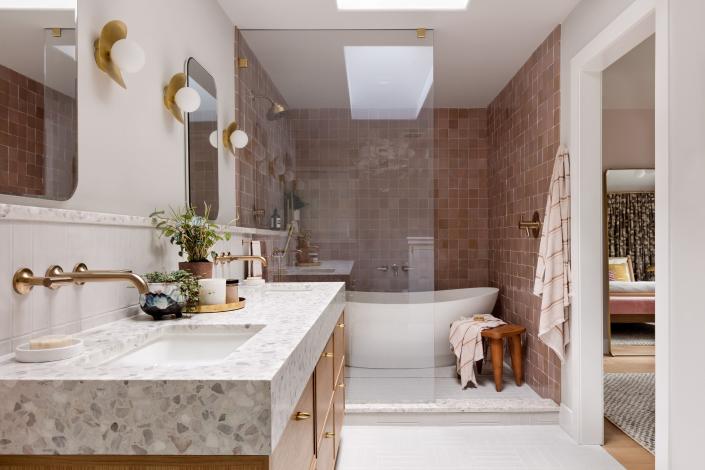 AFTER: “The client wanted a bathtub and there wasn't really room to have it be a separate area, so I just made all of it a wet zone,” reasons Amy. “I love the sculptural shape of this tub. Against the dusty pink tile, it really stands out.”