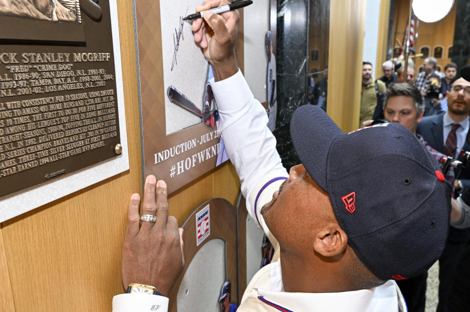 Newly elected Baseball Hall of Fame inductee Adrián Beltré signs his name to the backer board of his plaque during a news conference Thursday, Jan. 25, 2024, in Cooperstown, N.Y. (AP Photo/Hans Pennink)