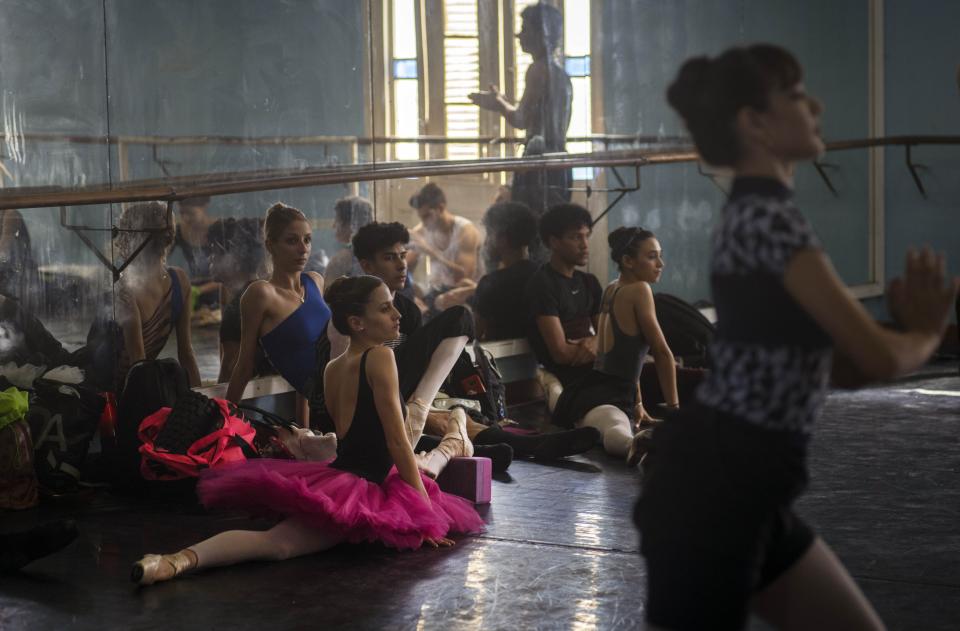 Members of the national ballet of Cuba stretch while they watch a practice directed by Viengsay Valdes in Havana, Cuba, Thursday, Dec. 12, 2019. Valdes, the new head of Cuba's legendary National Ballet, says she hopes to renew the institution after the death of long-time director Alicia Alonso by introducing new choreography and appearances by dancers who have emigrated to other companies. (AP Photo/Ramon Espinosa)