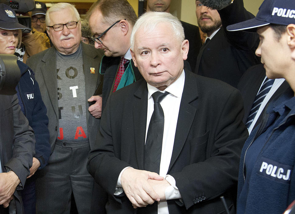 FILE - In this Thursday, Nov. 22, 2018 photo the head of the ruling party Jaroslaw Kaczynski,right, and former President Lech Walesa, second left, stay in front of a courtroom in Gdansk, Poland. The Appeals Court in Gdansk ruled Monday, July 22, 2019 that Walesa must apologize to Kaczynski for blaming him for a 2010 plane crash that killed Kaczynski's twin, then-President Lech Kaczynski. (AP Photo/Wojciech Strozyk, file)