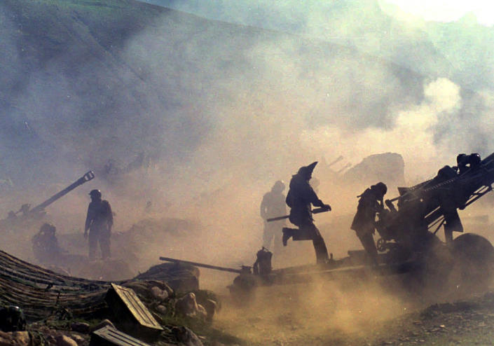FILE - Indian artillery guns are engulfed in smoke in Dras, some 155 kilometers (96 miles) in north of Srinagar, India, on Saturday, July 10, 1999. The conflict with Pakistan that raged for three months across the disputed Kashmir region had nearly brought the nuclear neighbors to a war. (AP Photo/Aijaz Rahi, File)