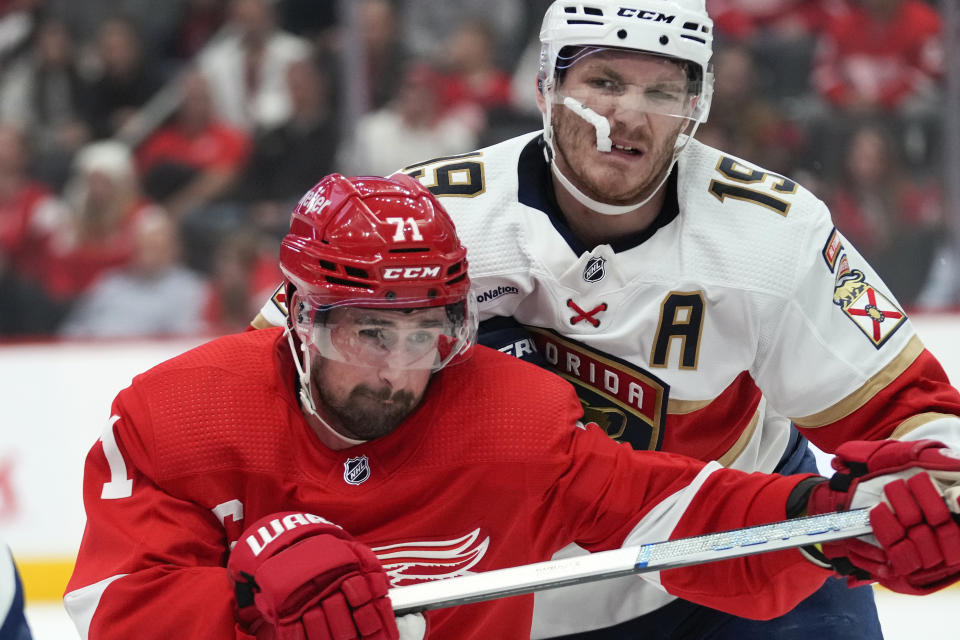 Detroit Red Wings center Dylan Larkin (71) and Florida Panthers left wing Matthew Tkachuk (19) battle for position in the second period of an NHL hockey game Thursday, Nov. 2, 2023, in Detroit. (AP Photo/Paul Sancya)