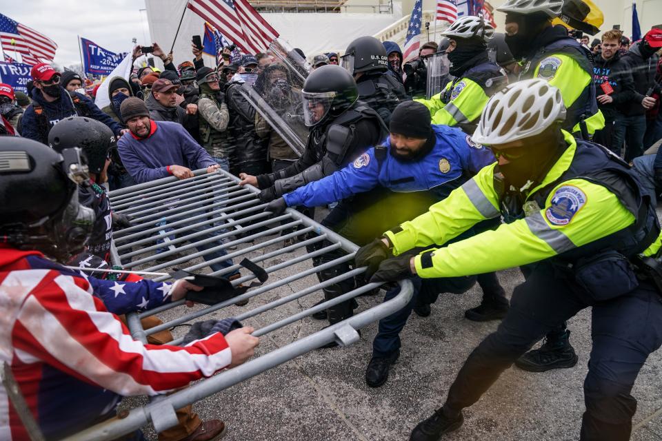 Rioters loyal to then-President Donald Trump try to break through a police barrier, Wednesday, Jan. 6, 2021, at the Capitol in Washington.