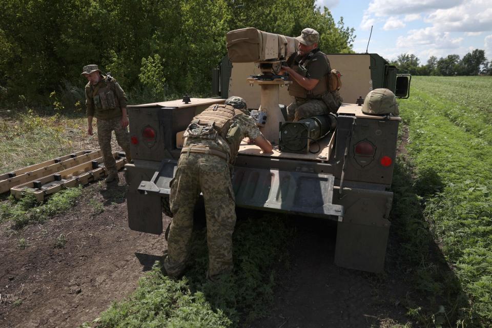 Ukrainian marines from the 37th Brigade install a rocket launcher on a vehicle in June at a position in the Donetsk region.