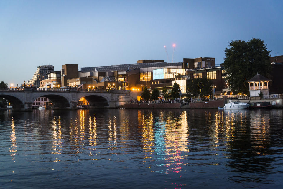 Kingston upon Thames, Surrey, England, UK - August 29, 2016: Kingston Bridge over the river Thames and Kingston riverside which is lined with restaurants and a popular spot with locals and tourists. The Thames river reflects the city lights at night.