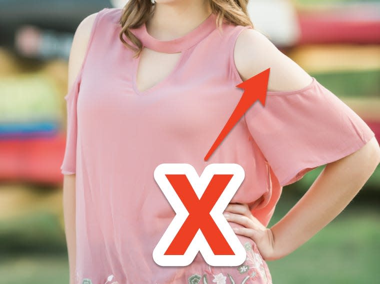 red x and arrow pointing at woman posing for the camera wearing pink cold shoulder top blouse