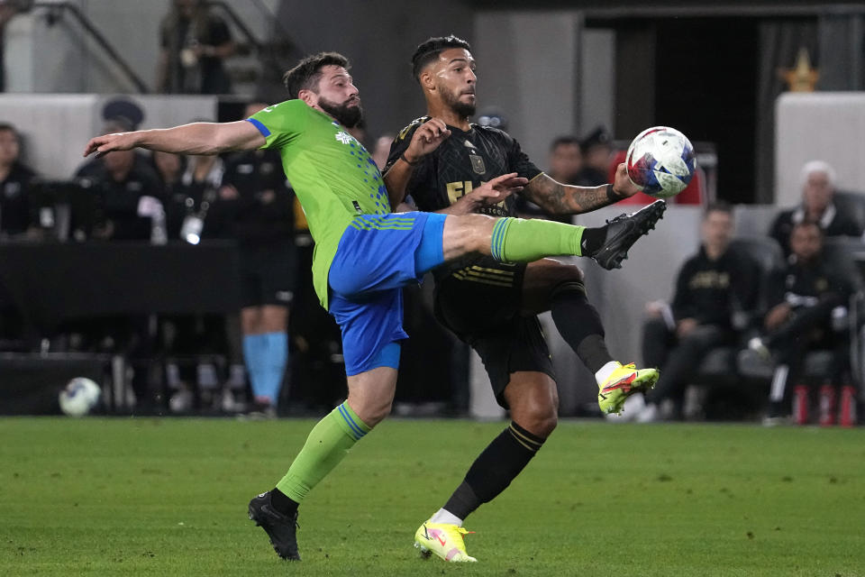 Seattle Sounders midfielder Joao Paulo, left, and Los Angeles FC forward Denis Bouanga try to kick the ball during the first half of a Major League Soccer match Wednesday, June 21, 2023, in Los Angeles. (AP Photo/Mark J. Terrill)