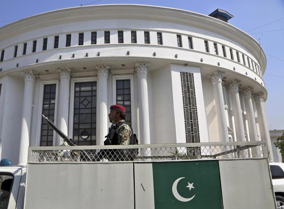 A paramilitary soldier guards outside the provincial assembly building as lawmakers arrive to cast their vote in senate elections, at the provincial assembly, in Peshawar, Pakistan, Wednesday, March 3, 2021. Pakistani lawmakers are choosing new members of the country's Senate, or upper house of parliament — a vote that is seen as a test for Prime Minister Imran Khan's government. Khan's ruling Pakistan Tehreek-e-Insaf party is seeking to improve its standing in the 104-member Senate, where it lacks a majority. (AP Photo/Muhammad Sajjad)