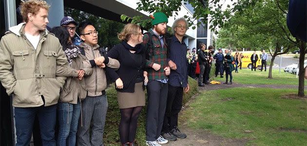 Protesters lock arms outside the Linking Melbourne Authority as police move in to remove them. Photo: Michael Scanlan (Twitter: @mscanlan7)