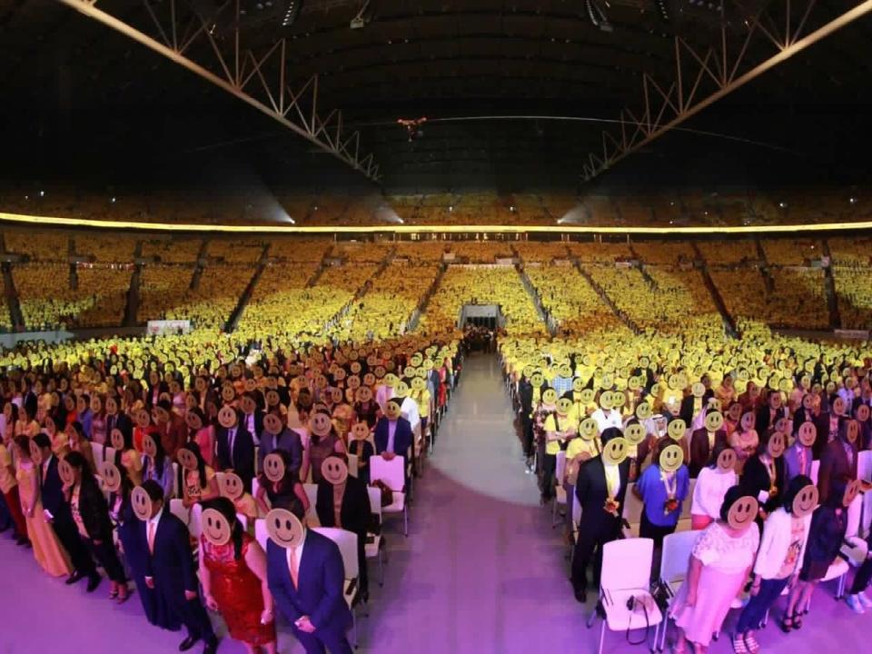 Most people wearing costume masks at a large gathering