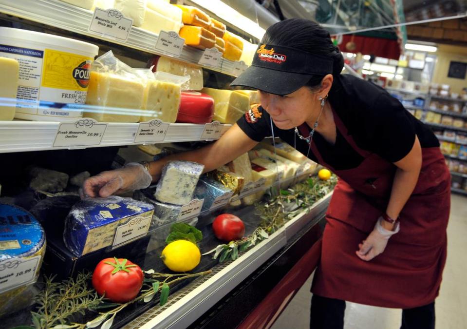 Marlene Goulet displays cheeses at Sam’s Italian Deli and Market in this file photo from 2014.