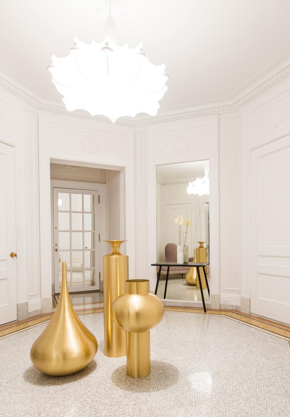 This 5,000-square-foot five-bedroom apartment in the Apthorp, a landmarked New York City condominium built in 1908, was designed by Megan Grehl of Homepolish. The foyer shows off a trio of Tom Dixon's “Beat” floor vessels, whose curvaceous shapes pair well with Marcel Wander’s “Mad” chaise lounge (seen in the mirror) and “Zeppelin” light pendant.