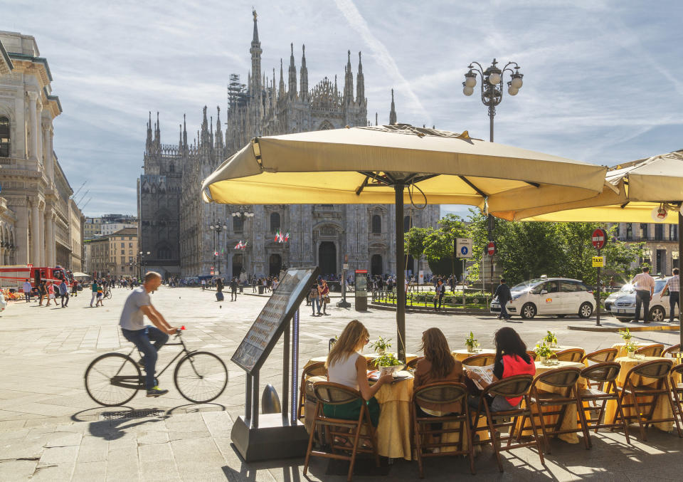 People sitting in a cafe facing a Cathedral.