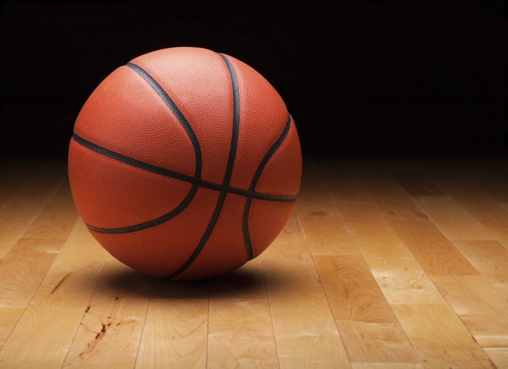 Basketball with dark background on a wood gym floor