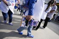 Fans carry bobbleheads of Los Angeles Dodgers designated hitter Shohei Ohtani before a baseball game against the Cincinnati Reds in Los Angeles, Thursday, May 16, 2024. (AP Photo/Ashley Landis)