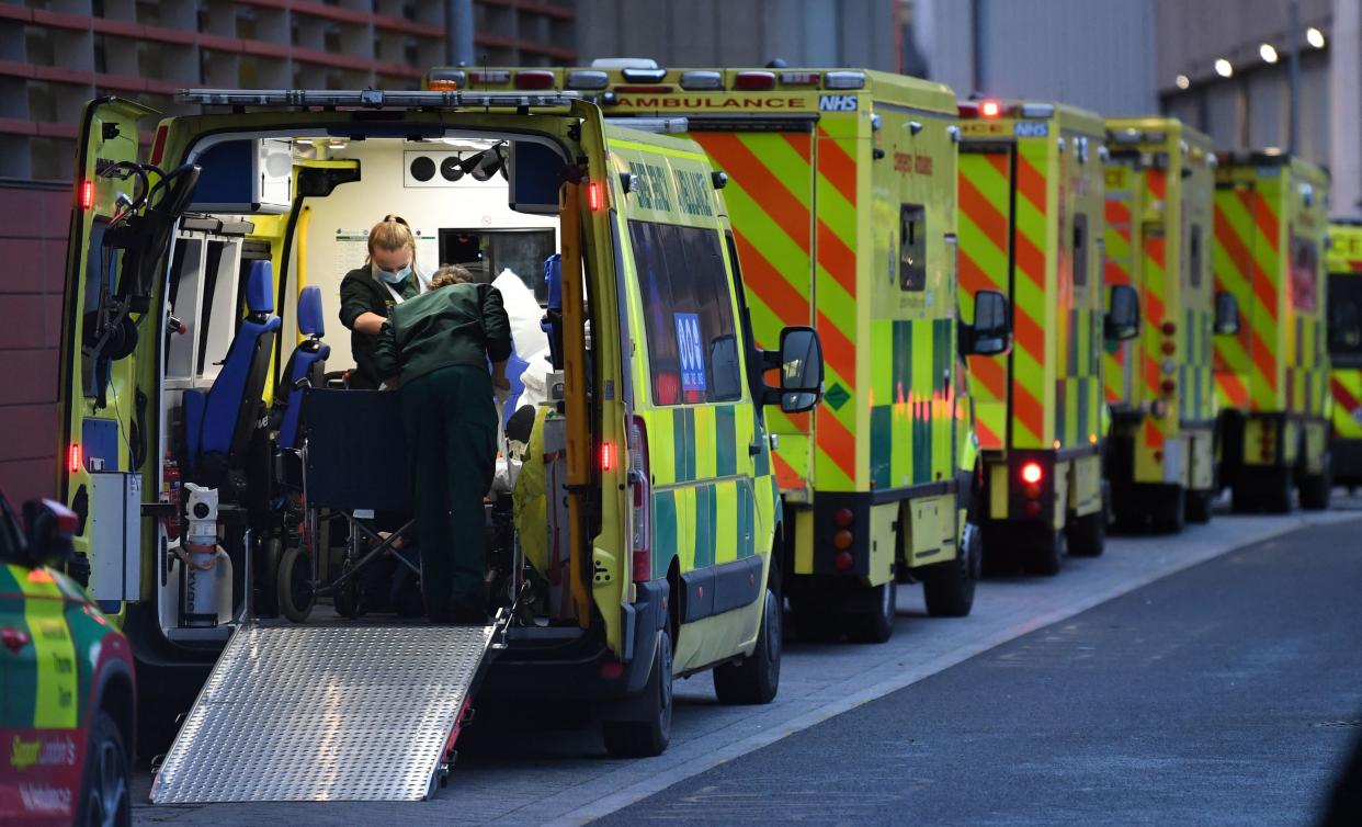 Ambulance crew members work in inside an ambulance parked outside the Royal London Hospital in east London on January  7, 2022. - Britain will deploy troops to hospitals in London to alleviate severe staff shortages caused by the Omicron outbreak, the Ministry of Defence (MoD) said Friday. (Photo by Daniel LEAL / AFP) (Photo by DANIEL LEAL/AFP via Getty Images)