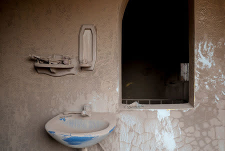 A bathroom covered with ash is seen inside a house affected by the eruption of the Fuego volcano at San Miguel Los Lotes in Escuintla, Guatemala, June 7, 2018. REUTERS/Carlos Jasso