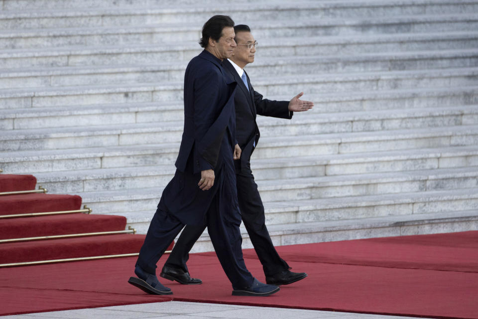 FILE - In this Tuesday, Oct. 8, 2019, file photo, Pakistan's Prime Minister Imran Khan, left, walks with Chinese Premier Li Keqiang during a welcome ceremony outside the Great Hall of the People in Beijing. Pakistan is seeking Chinese support in opening a U.N. inquiry into India's revocation of Kashmir's statehood, splitting it into two federal territories: Jammu and Kashmir, and Ladakh, something New Delhi says was made necessary by Pakistani political exploitation and lagging regional economic development. (AP Photo/Ng Han Guan, File)