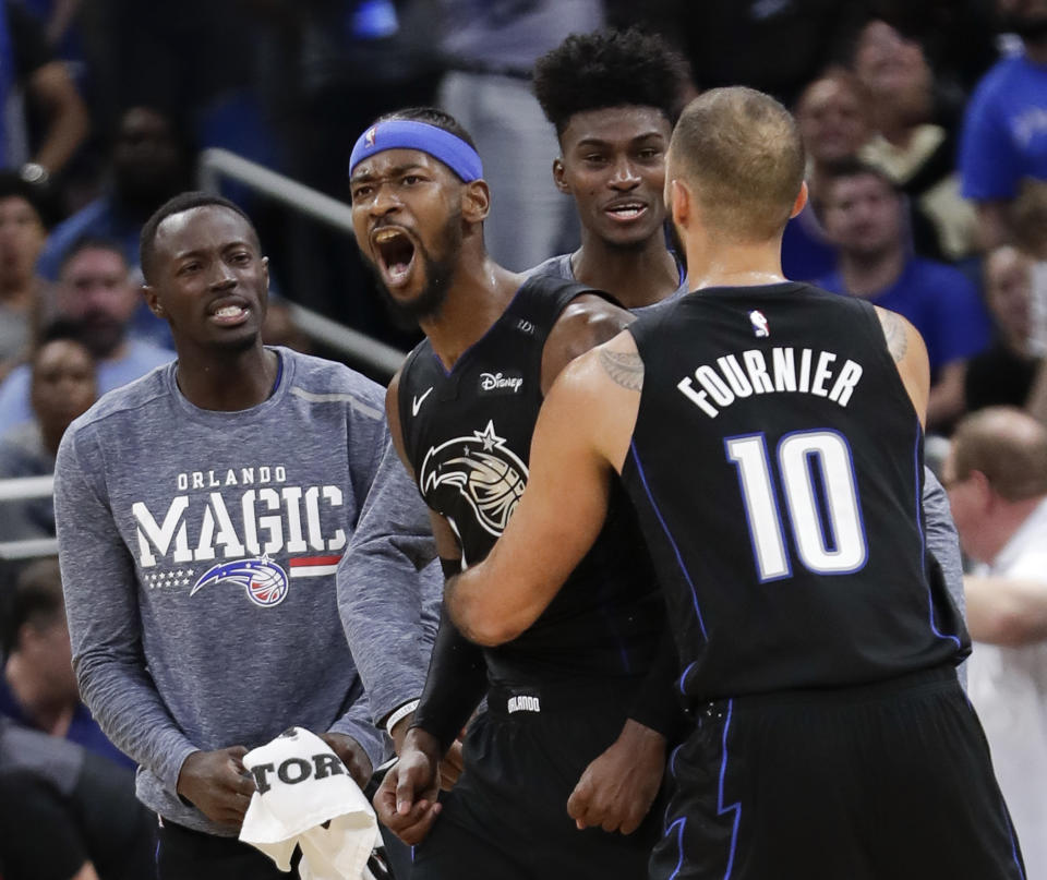 Orlando Magic's Terrence Ross, second from left, celebrates after sinking a 3-point shot against the Philadelphia 76ers with Jerian Grant, left, Jonathan Isaac, second from right, and Evan Fournier (10) in the finals moments of an NBA basketball game Wednesday, Nov. 14, 2018, in Orlando, Fla. (AP Photo/John Raoux)