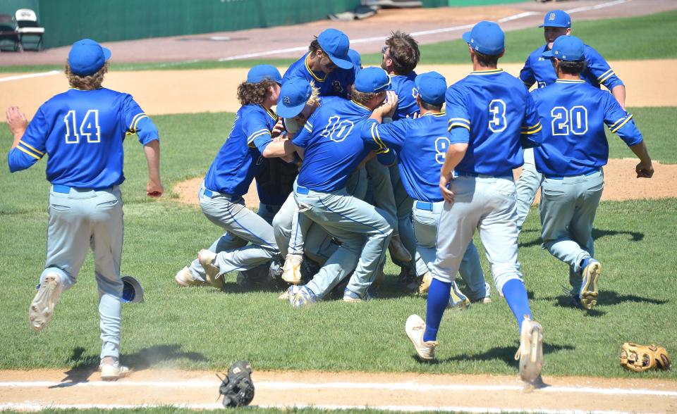 Gloves fly and players charge onto the infield grass as Clear Spring starts a dog-pile celebration after defeating Colonel Richardson 11-3 on May 28 to win the Class 1A state championship.