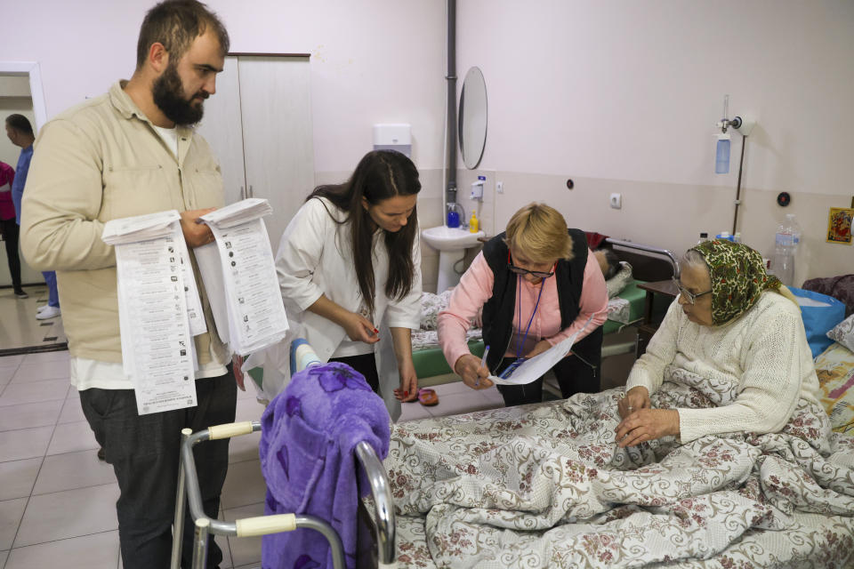 An elderly Moldovan woman is helped to cast her vote, at a hospital, during local elections in Chisinau, Moldova, Sunday, Nov. 5, 2023. Moldovans are casting ballots in nationwide local elections amid claims by Moldovan authorities that Russia has been conducting “hybrid warfare” to undermine the vote in the European Union candidate country. (AP Photo/Aurel Obreja)