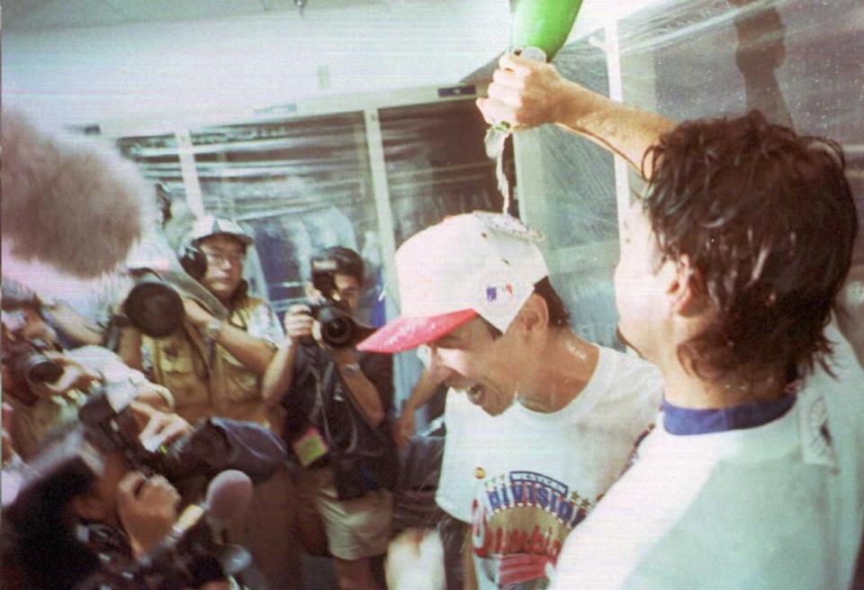Hideo Nomo has champagne poured over his head after a win that clinched at least a tie of the NL West title.