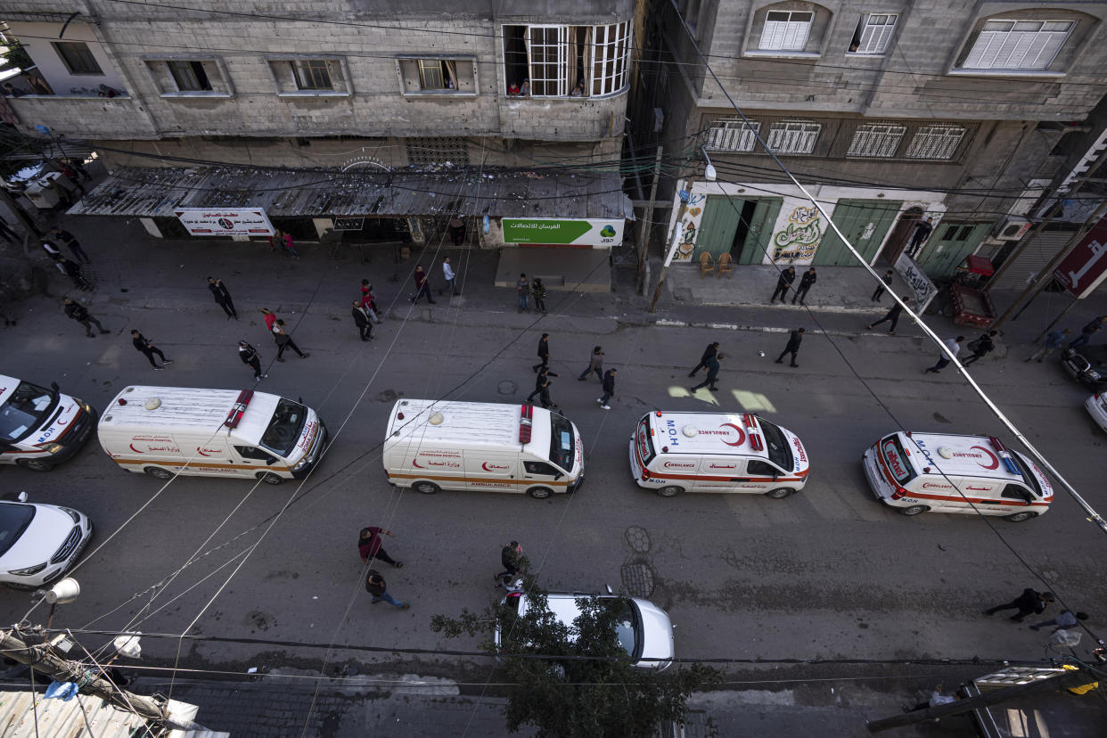 Ambulances carry the bodies of the Palestinians killed a fire in their apartment building in the Jebaliya refugee camp, northern Gaza Strip, Friday, Nov. 18, 2022. A fire set off by stored gasoline in a residential building killed 21 people Thursday evening in a refugee camp in the northern Gaza Strip, the territory's Hamas rulers said, in one of the deadliest incidents in recent years outside the violence stemming from the Israeli-Palestinian conflict. (AP Photo/Fatima Shbair)