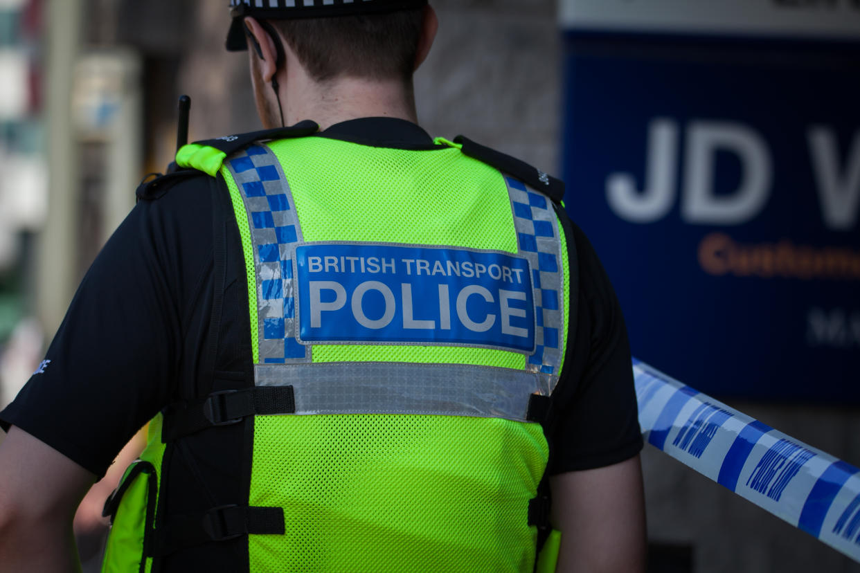 British Transport Police Officer, BTP, from the back next to a police cordon in Manchester.