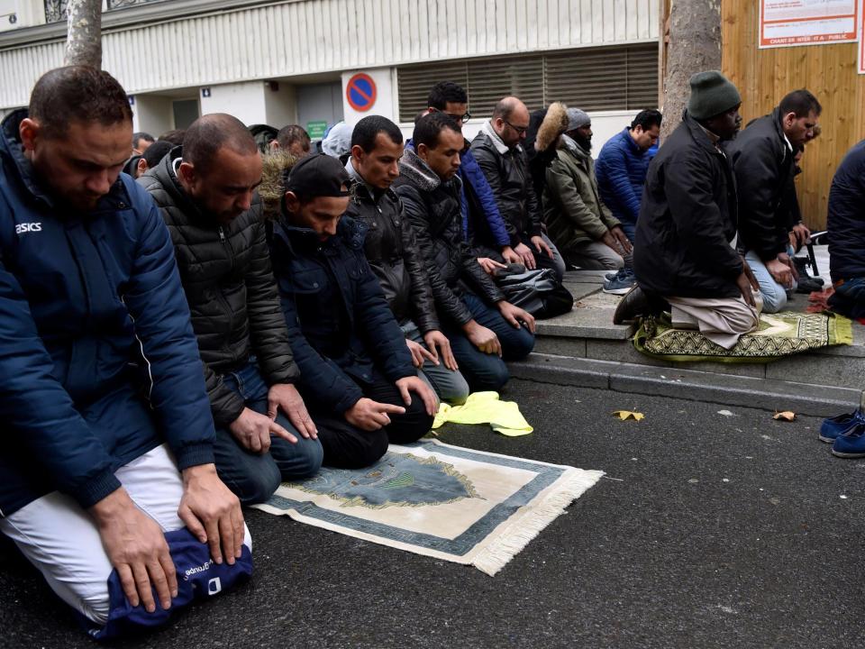 People pray in a street on 10 November in Clichy, near Paris, while the city mayor demonstrate with others political leaders against Muslim streets prayers: ALAIN JOCARD/AFP/Getty Images