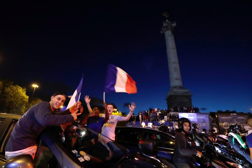 <p>Motorists and bystanders wave flags as they celebrate France’s victory at Bastille in Paris on July 10, 2018, after the final whistle of the Russia 2018 World Cup semi-final football match between France and Belgium. (Photo by Thomas SAMSON / AFP) </p>