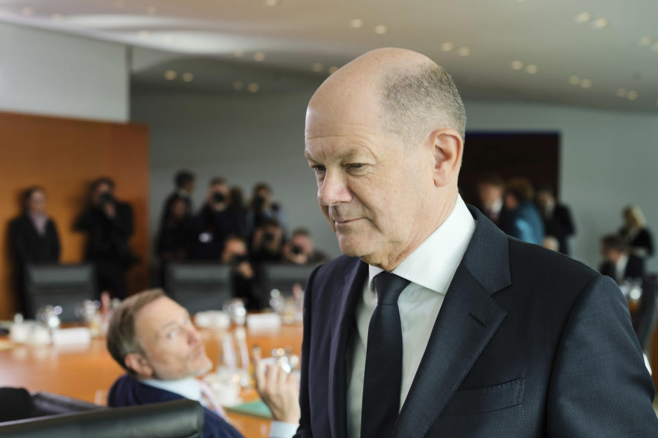 German Chancellor Olaf Scholz, right, goes to his seat after talking with German Finance Minister Christian Lindner, left, during the cabinet meeting of the German government at the chancellery in Berlin, Germany, Wednesday, Jan. 24, 2024. (AP Photo/Markus Schreiber)